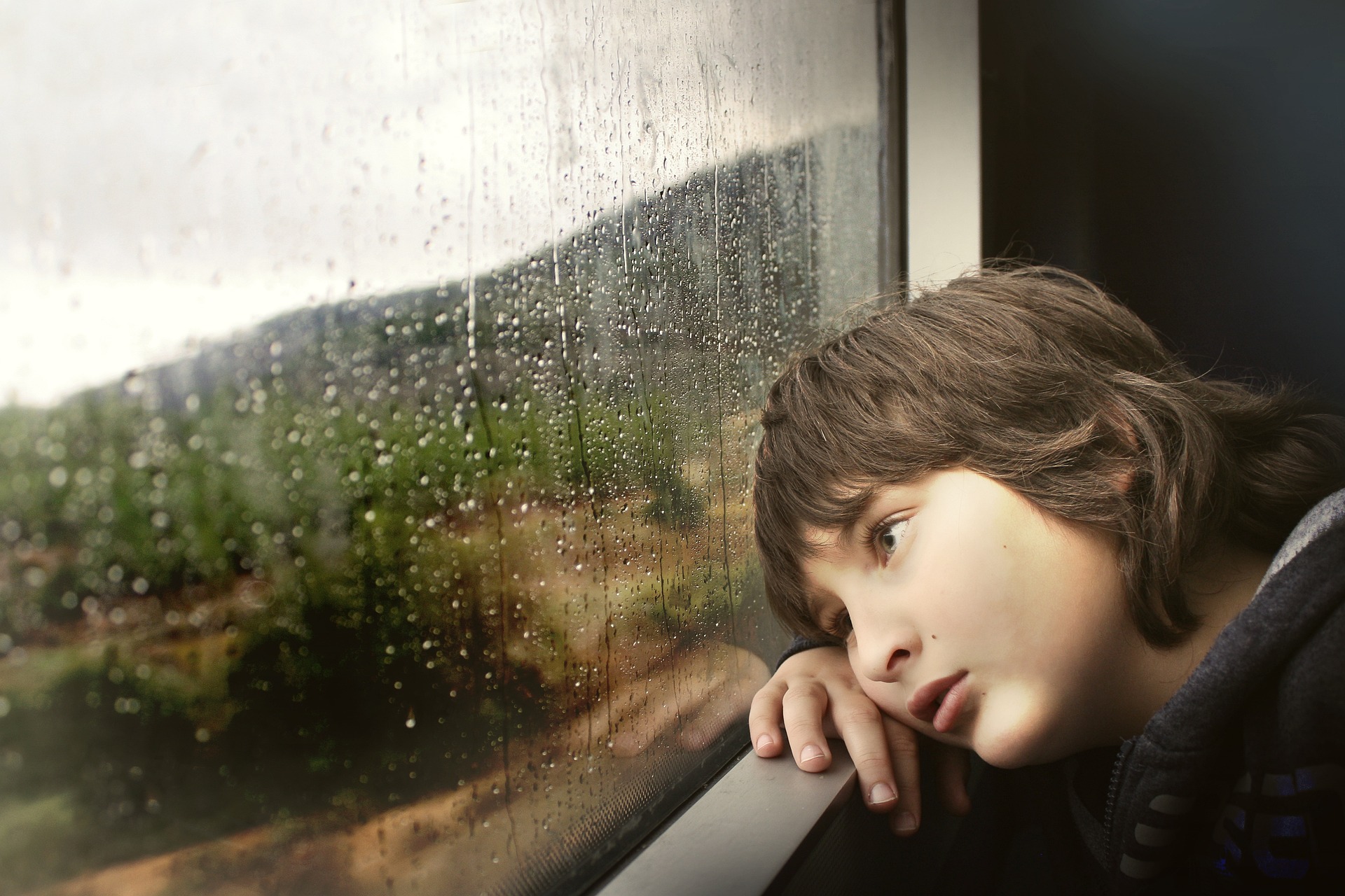 A person gazing out of a window, visualizing a hopeful and bright future