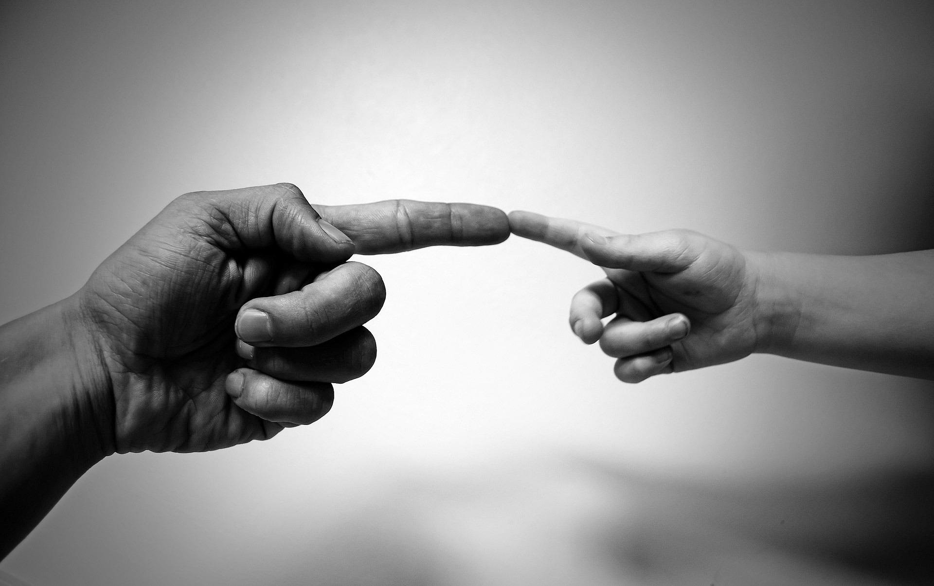 A person standing confidently while others in the background gossip or point fingers.